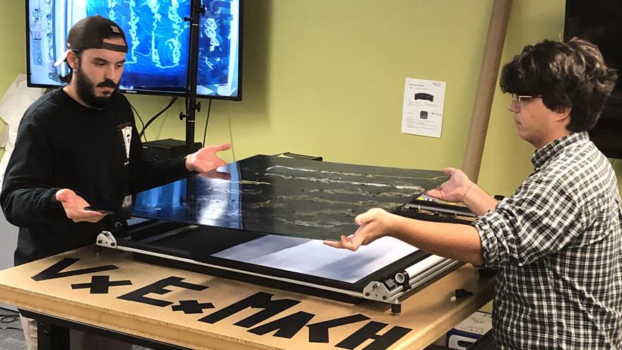 students lifting artwork