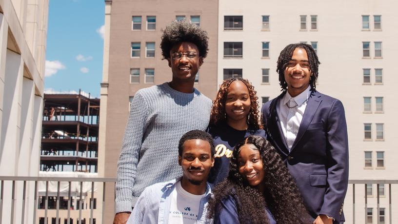 Five students in front of University Crossings