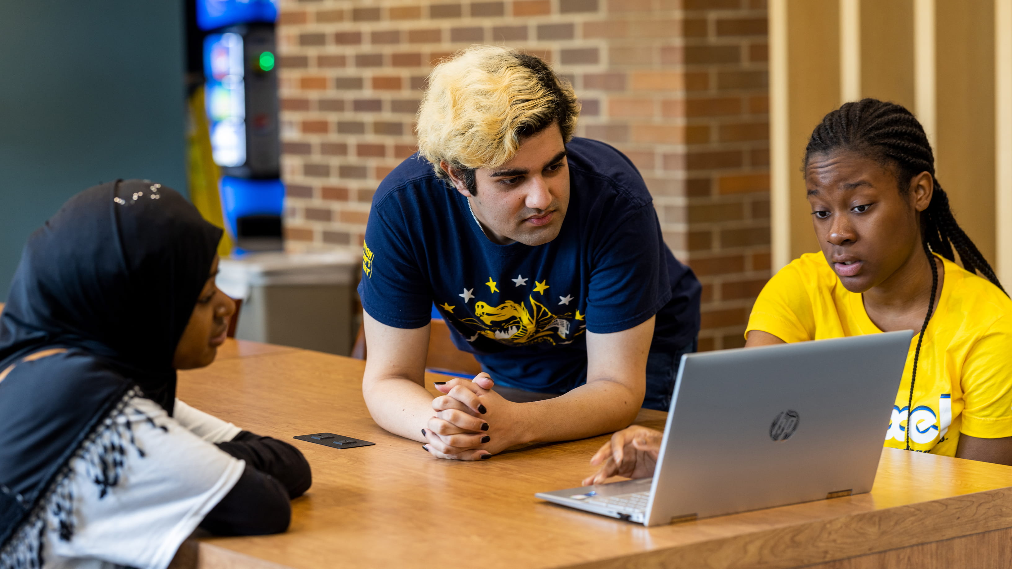 students around computer at bently lounge
