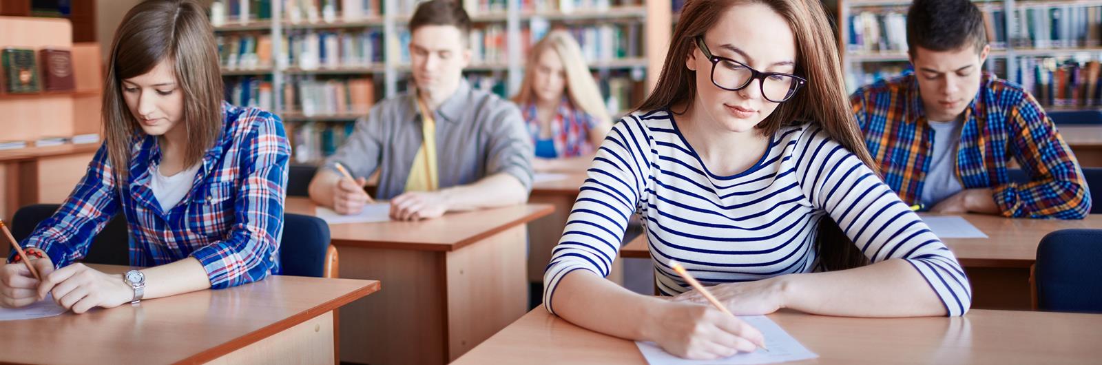 Serious student writing test at college.