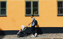 father pushing a stroller down street