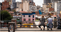 Two people sitting overlooking a city