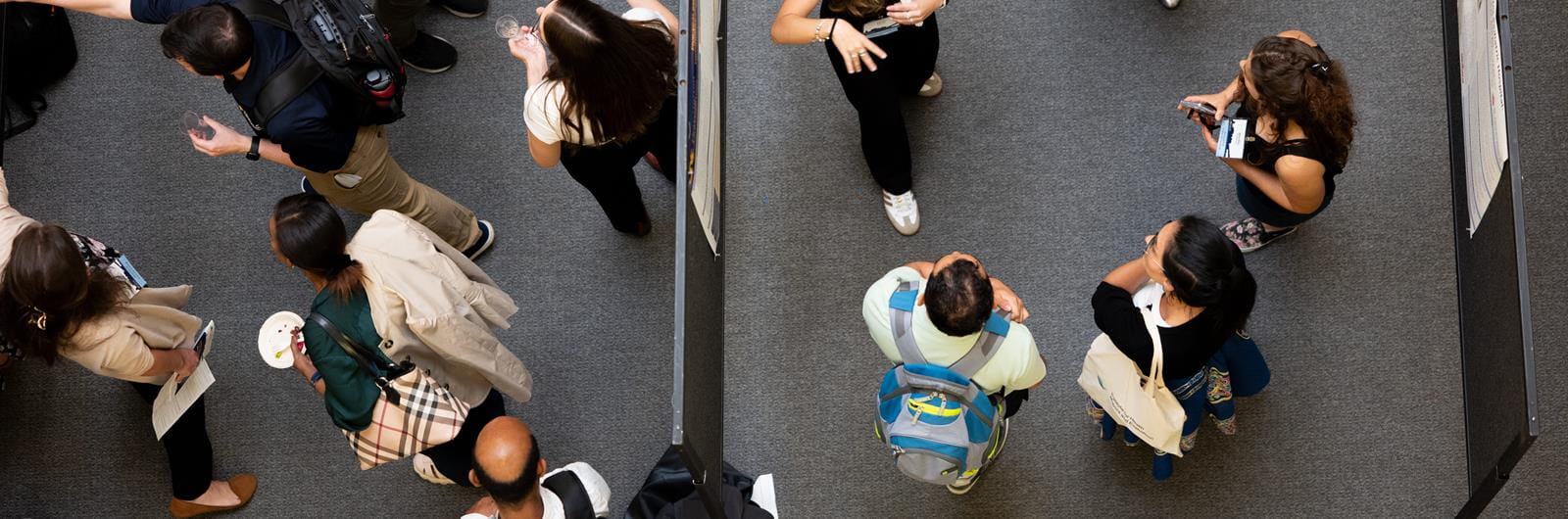 Overhead shot of researchers discussing their posters during UHC' 2025 Symposium 