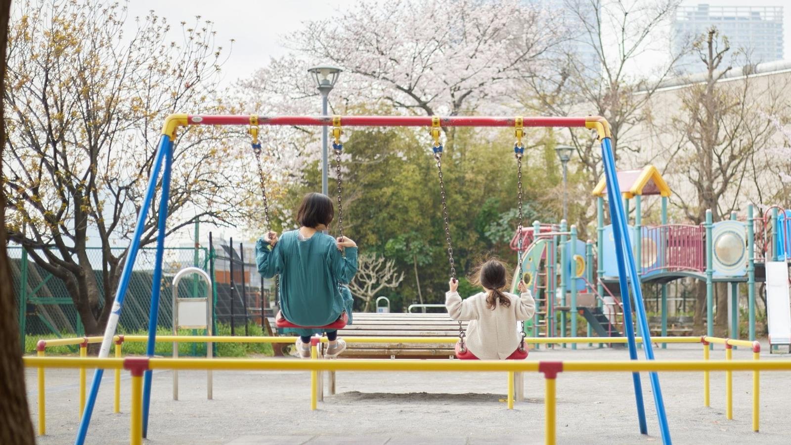 two children swinging at a playground