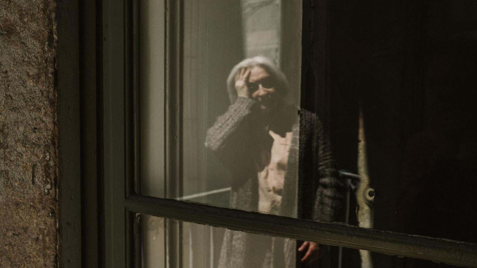 Window reflection of senior citizen