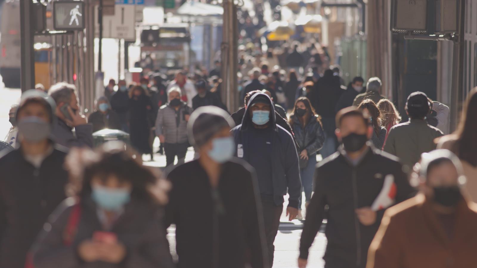 Crowd of people walking street wearing masks during COVID-19 coronavirus pandemic in New York City in November 2020