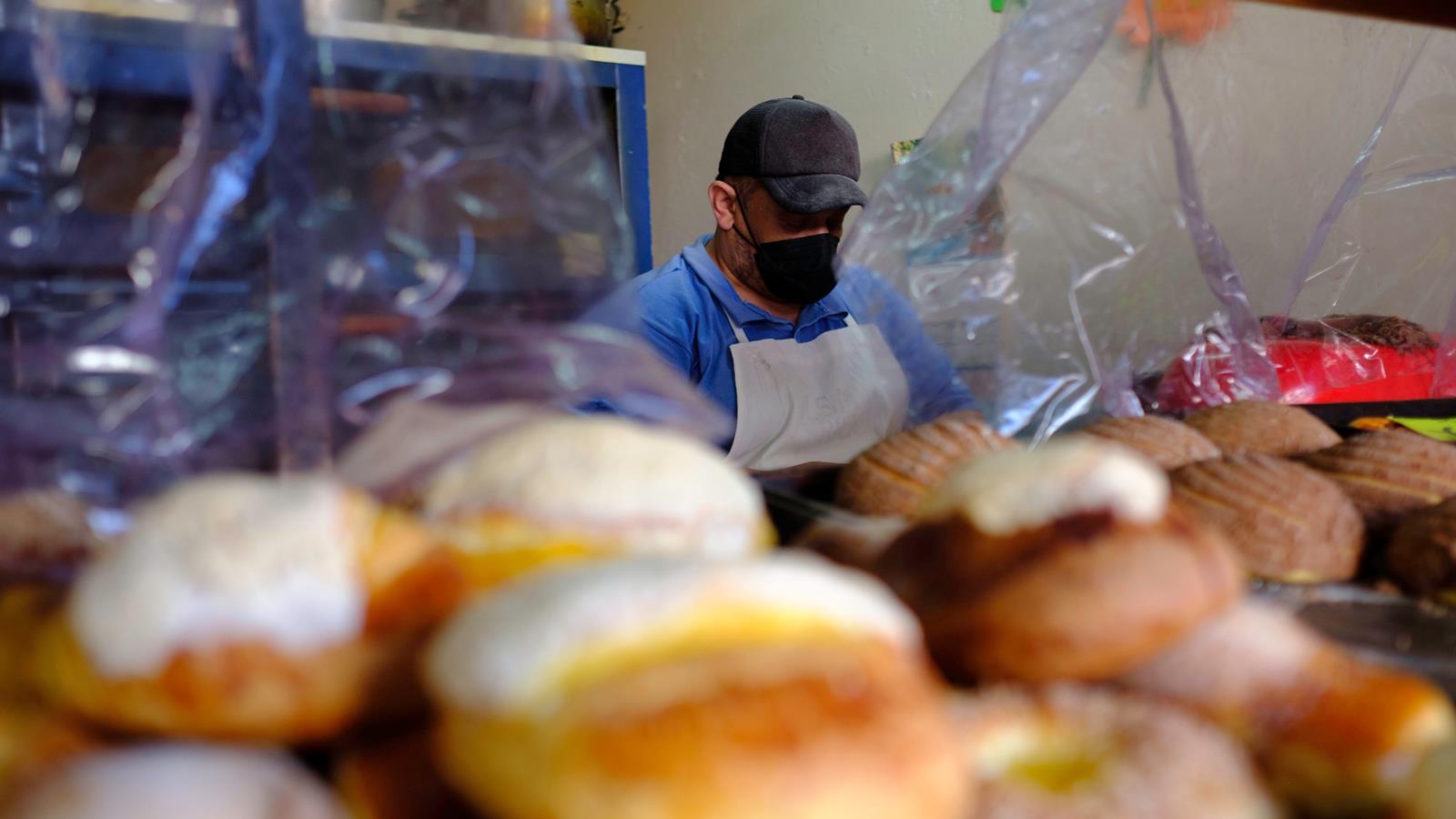 Latino man wearing a mask and working in a bakery
