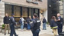 Police officers and community residents standing and getting coffee on a sidewalk