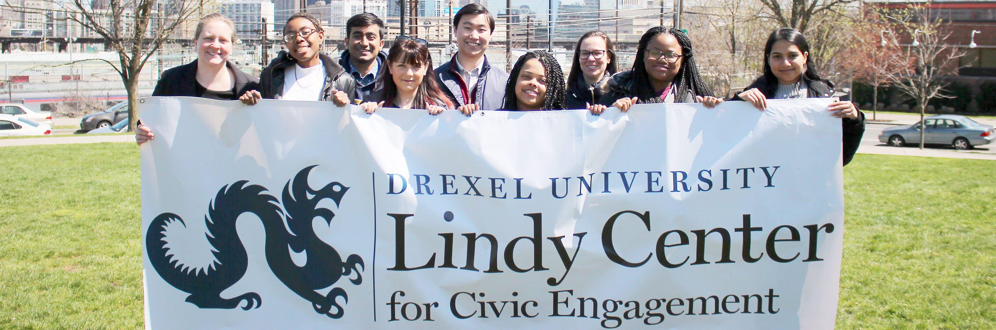Students holding a sign that says Drexel University Lindy Center for Civic Engagement