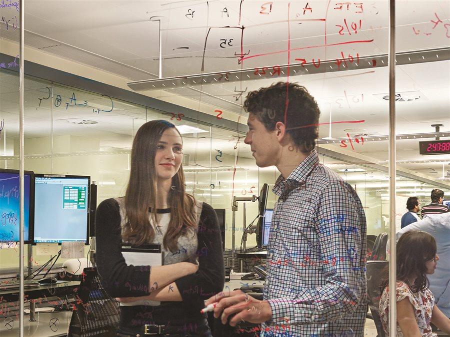Two students converse in a computer lab