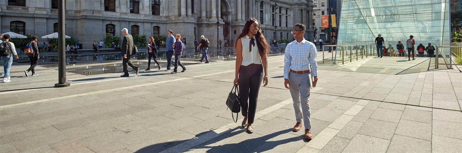 Two Drexel students walking across Dilworth Park in front of City Hall