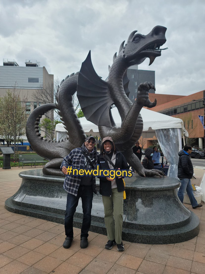 Admitted student with their parent in front of the Dragon statue