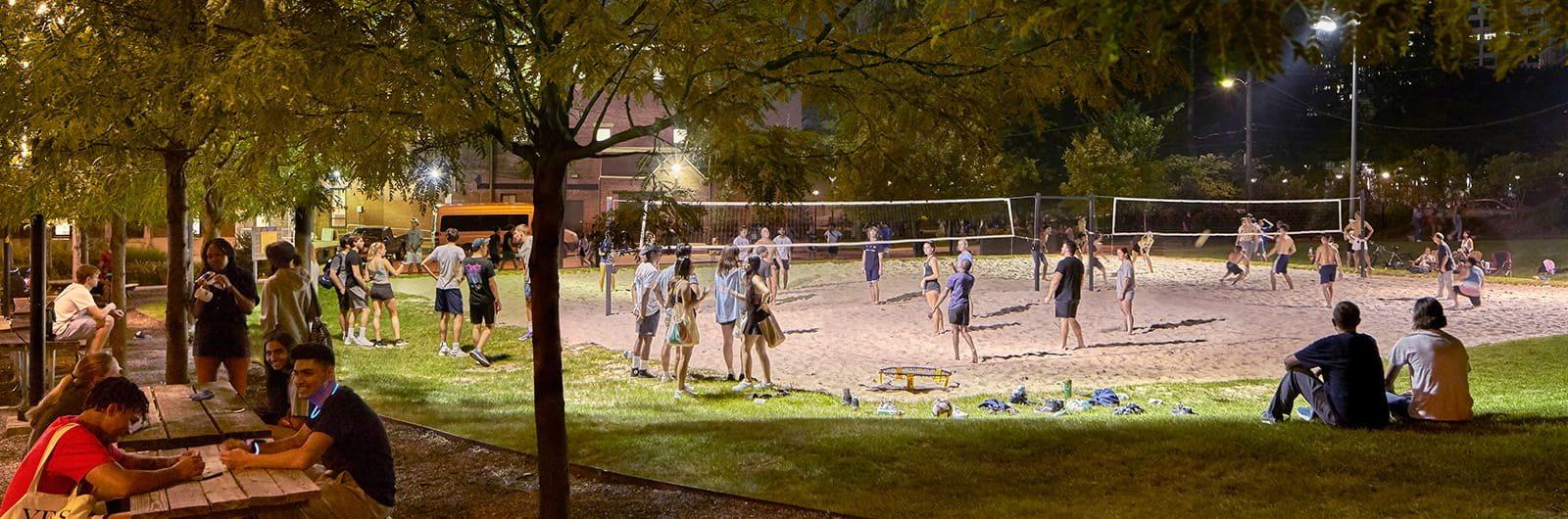 Students playing volleyball at night