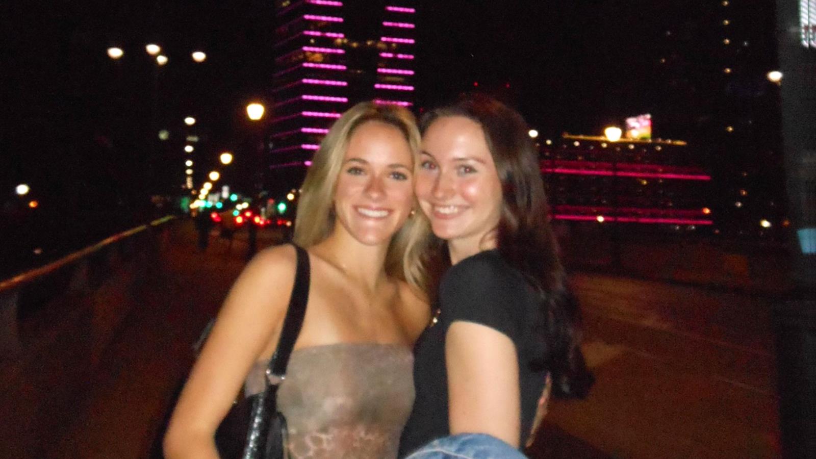 Two women posing in front of the city skyline