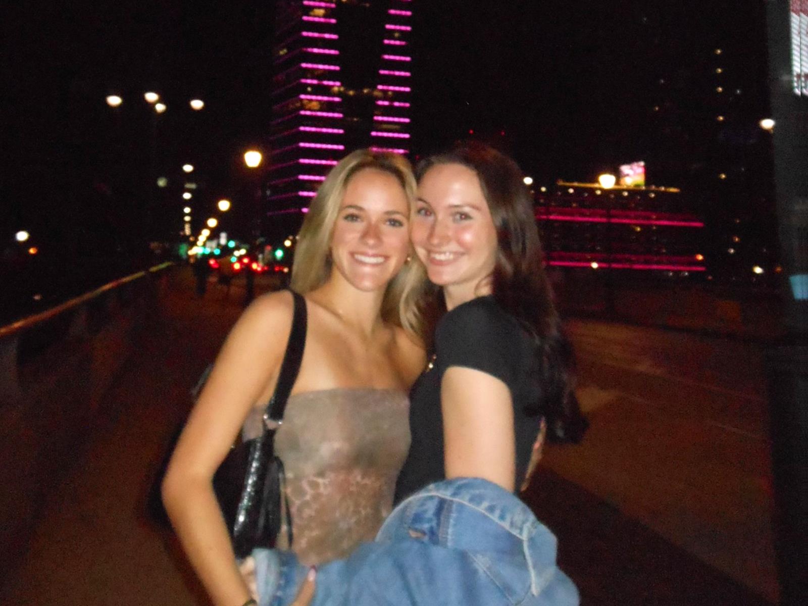 Two women posing in front of the city skyline