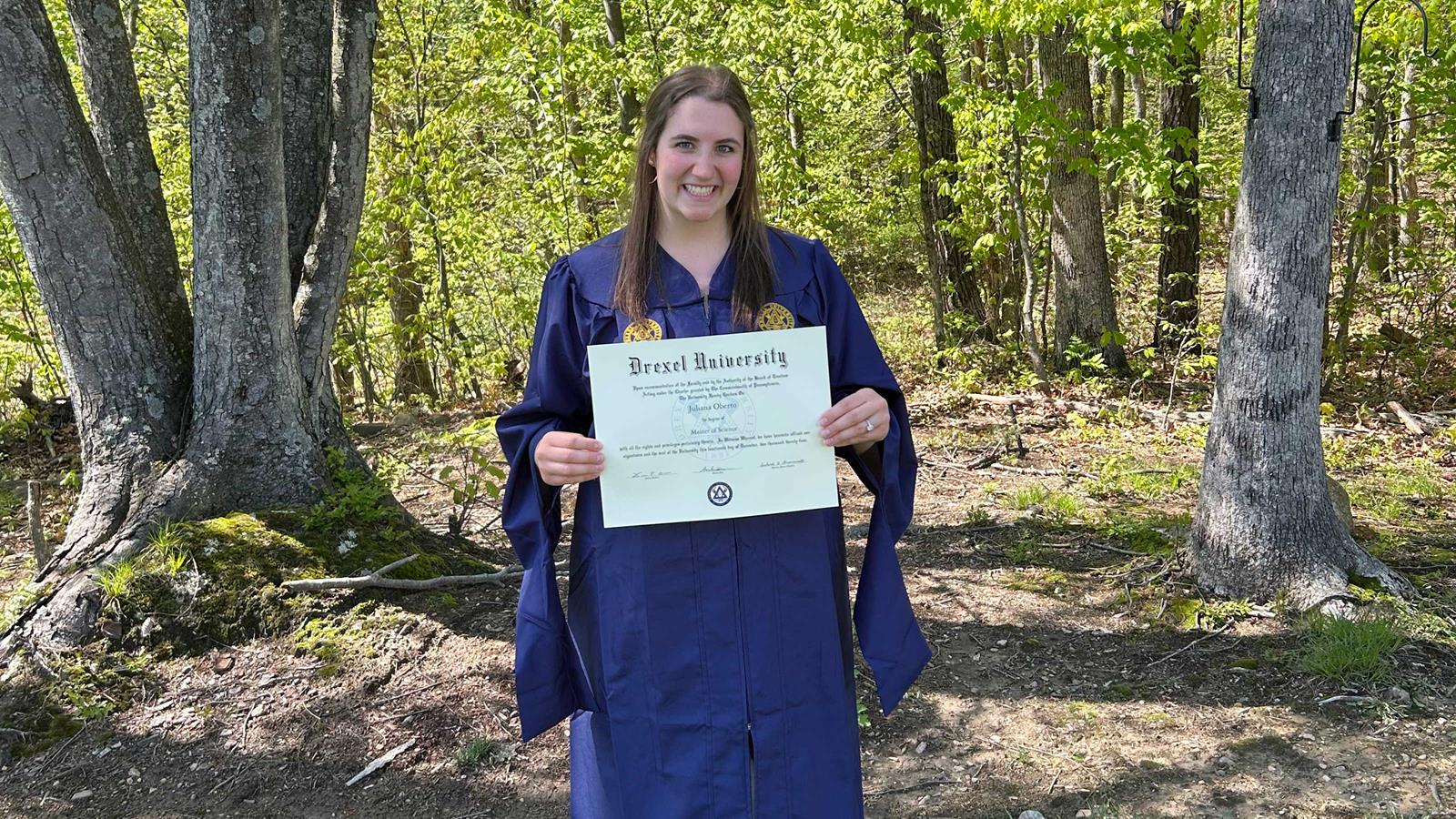 A Drexel alumna proudly holding her diploma