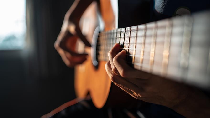Close up image of a person playing guitar