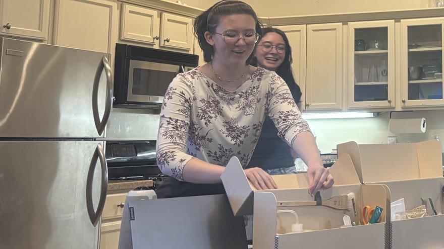 Terra Waymire-Rozman watches as Sophia Stutte shows points out tools and supplies in the conservation supply kits they both created and used when working on conservation projects. 