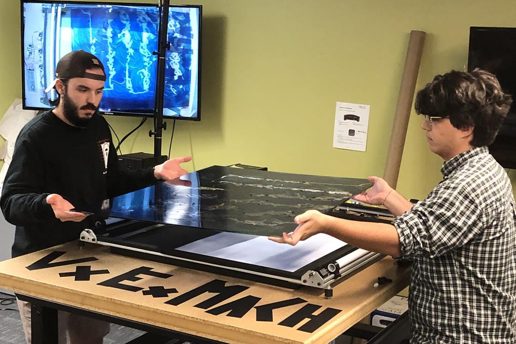 students lifting artwork