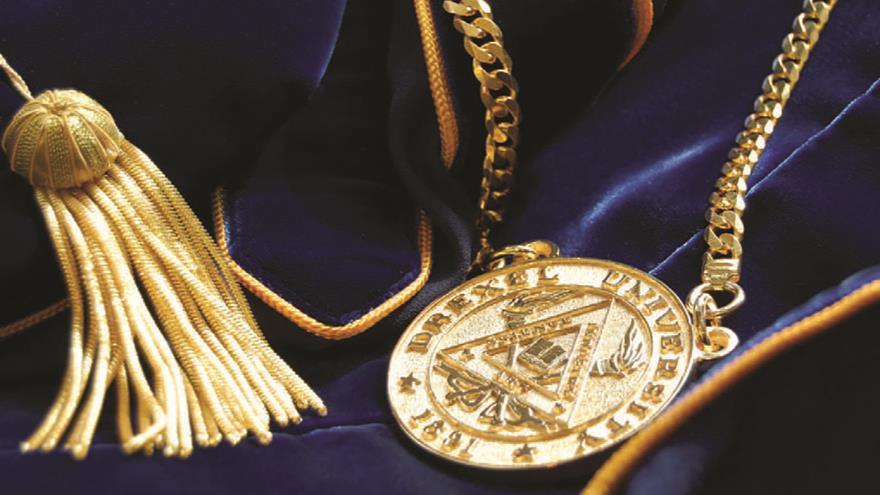A gold medallion and tassel on a blue velvet fabric.