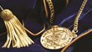 A gold medallion and tassel on a blue velvet fabric.