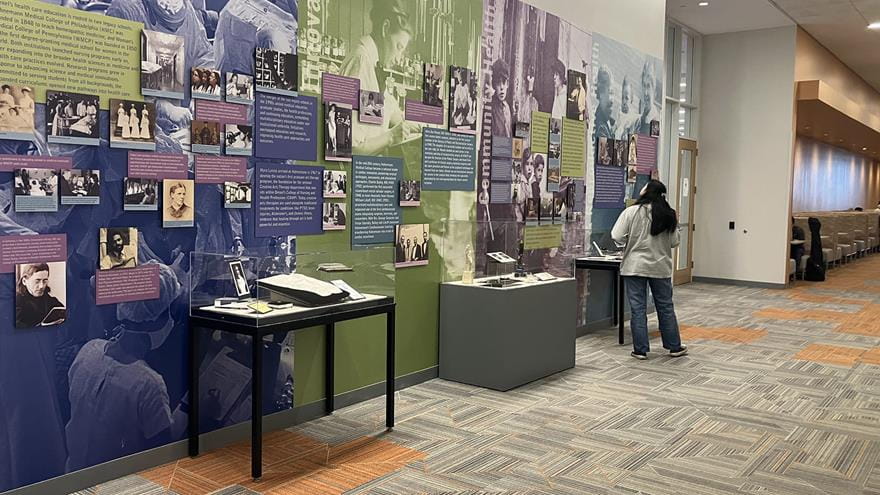 Daniela Lopez, graduating psychology major, viewing the Legacy Center’s new Health Sciences History Gallery on the second floor of the Health Sciences Building. Photo courtesy Legacy Center Archives & Special Collections.