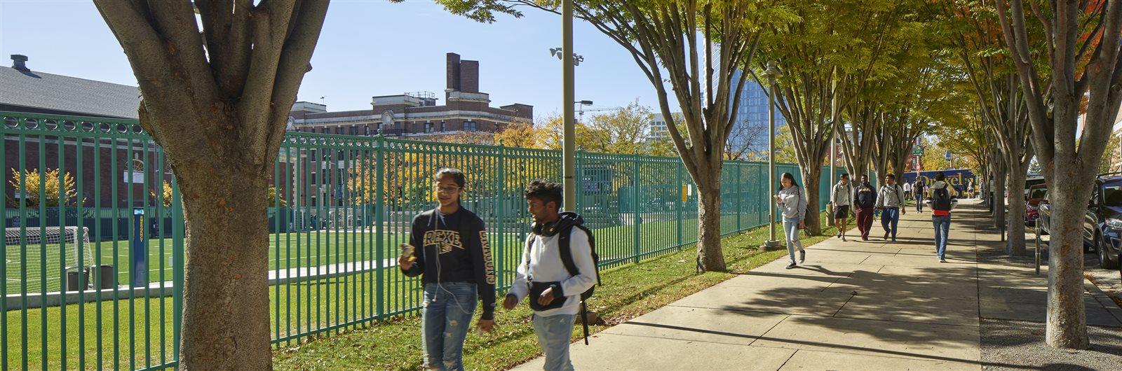 Two students walking by Buckley Recreational Field