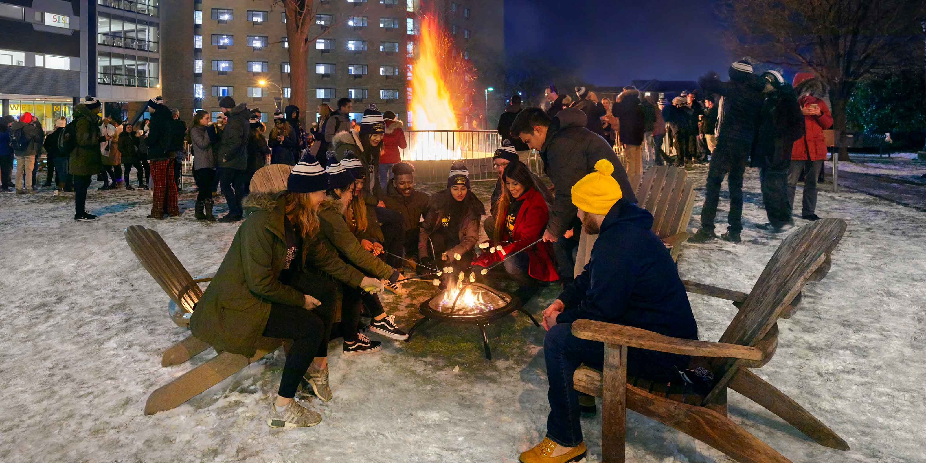 students around a bonfire on campus