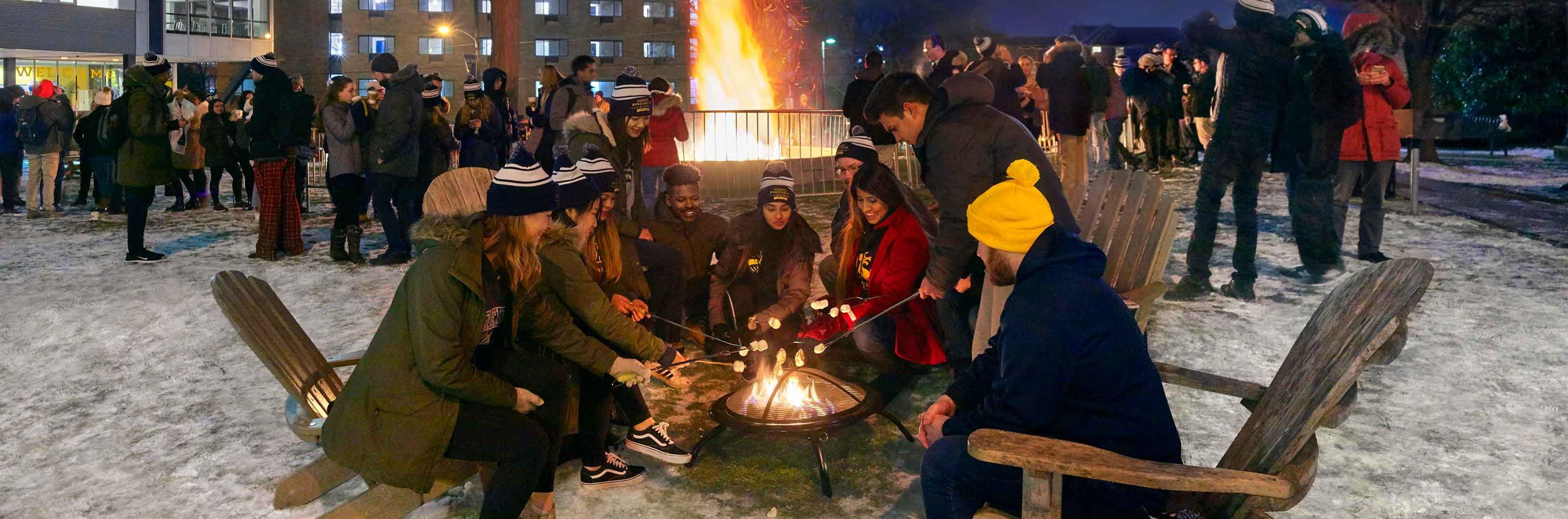 students around a bonfire on campus