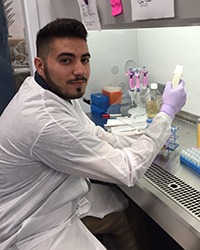 Zaid Salman in the lab holding lab equipment