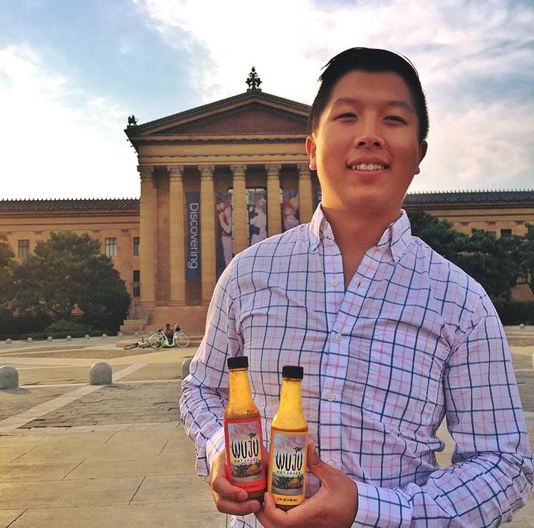 Wu holding bottles of hot sauce