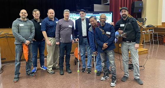 8 fathers standing in a row smiling at camera