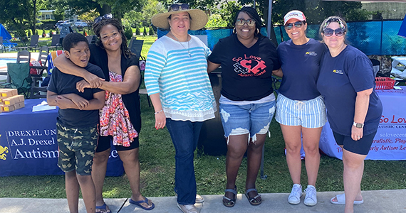 Group of individuals standing together posing for picture at The Nile Swim Club. 