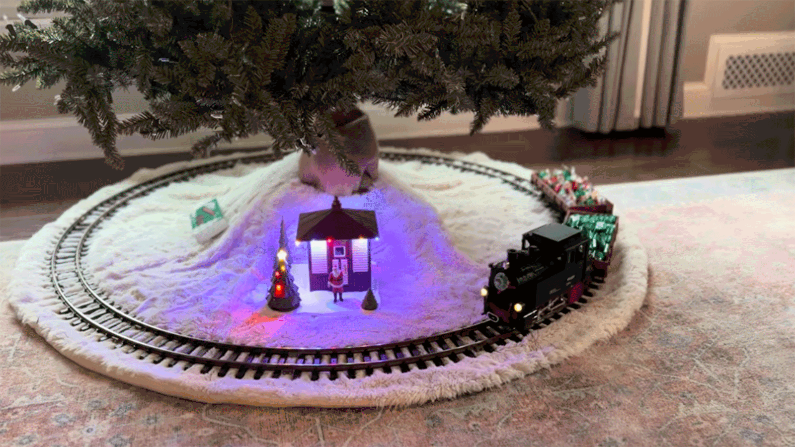 An electric toy train encircling a decorated tree