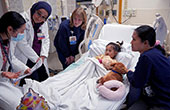 Image of healthcare professionals with a pediatric patient and mother.