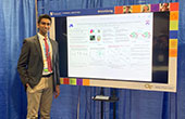 Photo of Drexel student Abishek Jeyapratap standing next to research poster