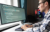 Image of man typing cybersecurity code on a desktop computer 
