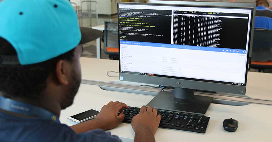A student sits typing at a desktop computer with Google Cloud on its screen. Students in the BSCST program can now access hands-on course exercises via cloud technology, giving them flexibility to complete their work from anywhere.