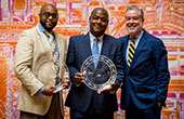 Photo of Rev. Christopher Holland II and Lawrence James with Drexel President John Fry at an awards ceremony