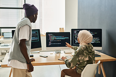 Stock photo; colleagues collaborating while coding at a computer