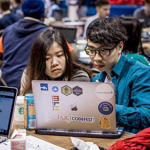 Two students working on a laptop while competing at Philly Codefest