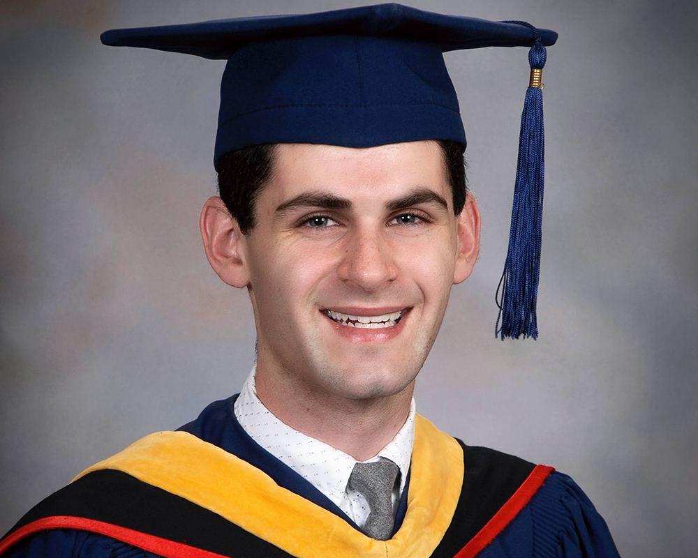 Portrait photo of Daniel Schwartz wearing his graduation cap and gown