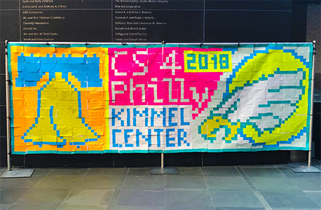 Post-It notes make up an image of the Liberty Bell and Philadelphia Eagles logo in an activity designed to teach students about how images can be compressed to share over networks.