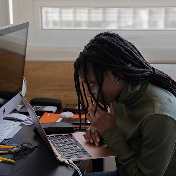 Woman in gray hoodie working on desktop computer