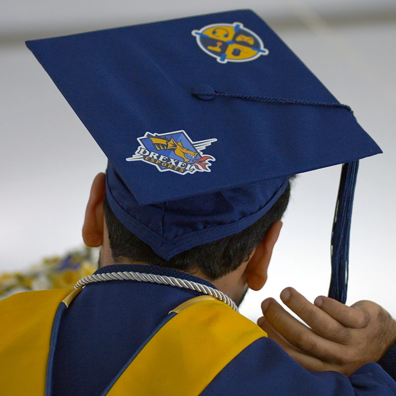 Photo of the back of the head of a student wearing blue mortarboard