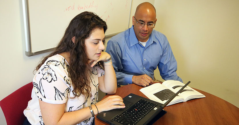 Student and faculty member with computer