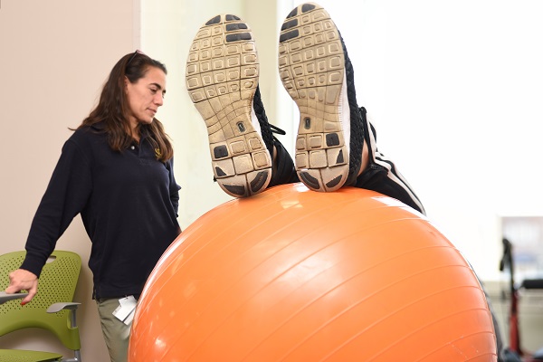 Sarah Wenger, PT, DPT works with patient using a exercise ball