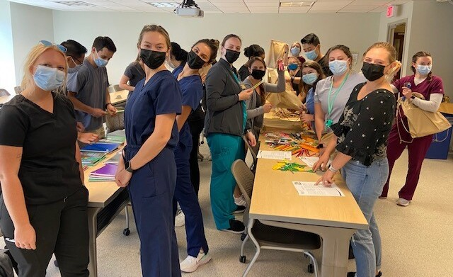 photo of 15-20 PA students, masked, creating flood buckets