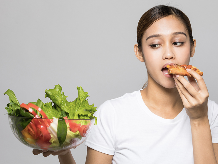 delicious foods-woman-eating-while-holding-a-salad