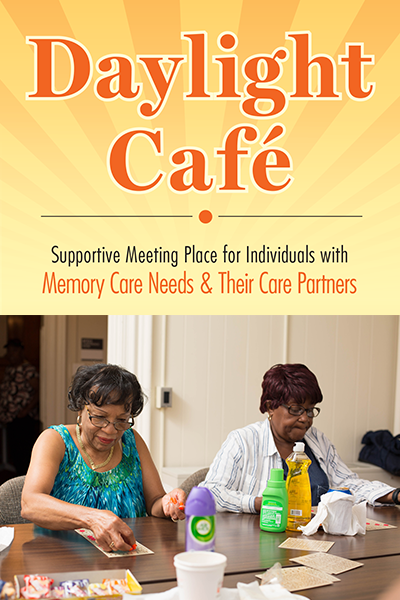 Two older women of color sitting at a table with the Daylight Cafe graphic